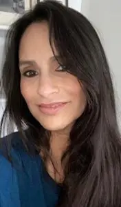 A woman with long black hair smiles for the camera.