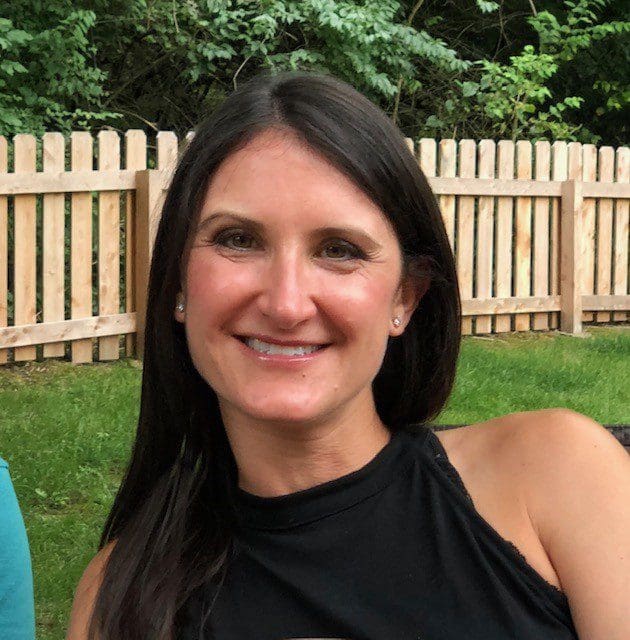 A woman in black shirt smiling for the camera.